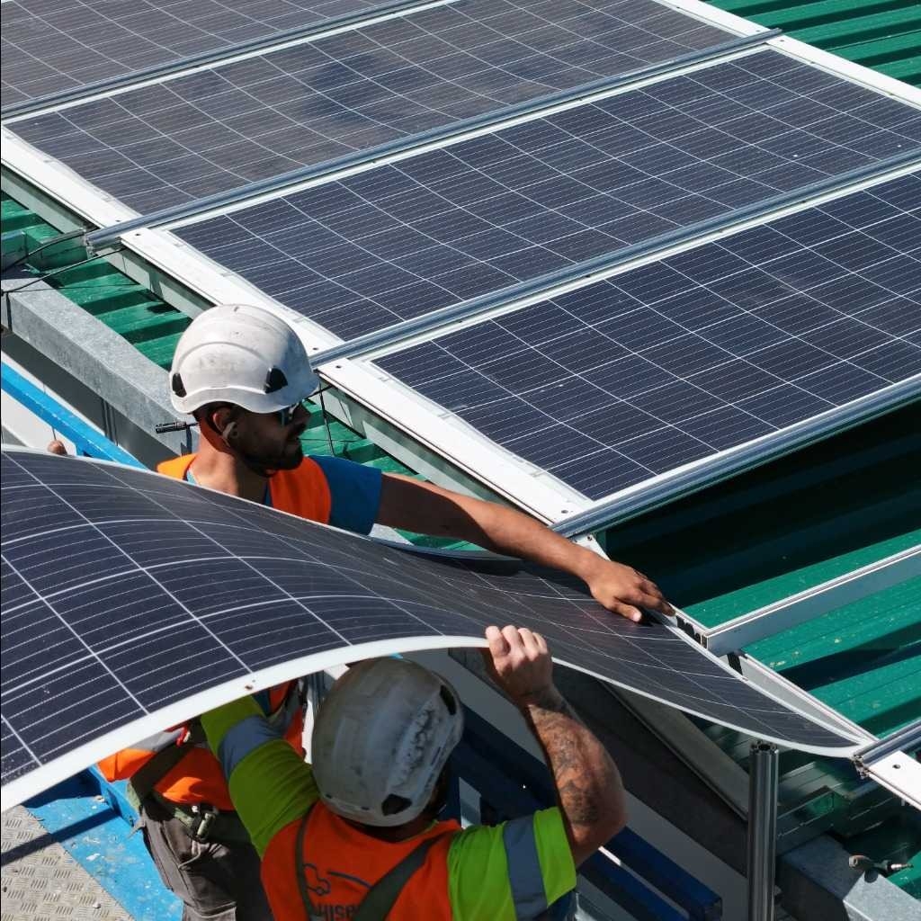 trabajadores-colocando-placas-solares-techo-feria-libro-madrid.jpg